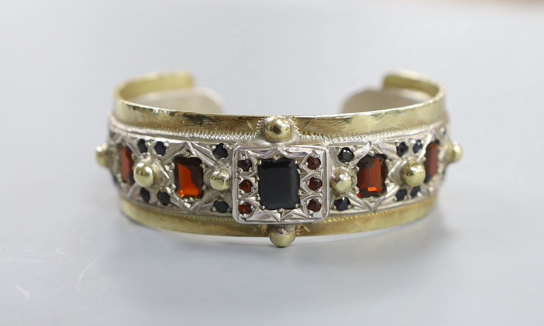 A modern parcel gilt silver and gem set open work bangle by Michael Allen Bolton, London, 1993, interior diameter 56mm, gross weight 67 grams.